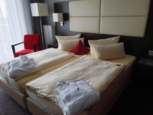 Hotelzimmer mit Bett und Bademantel