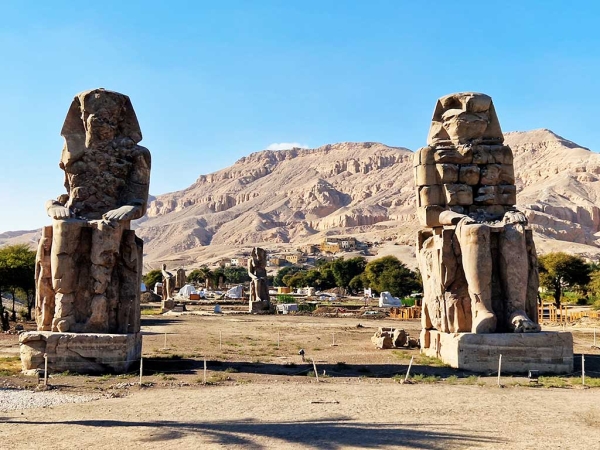 Zwei große Steinstatuen in Luxor. Sie werden als Memnon Kolosse bezeichnet.